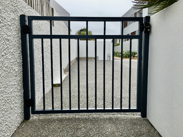 narrow house home side gate passage black metal bars